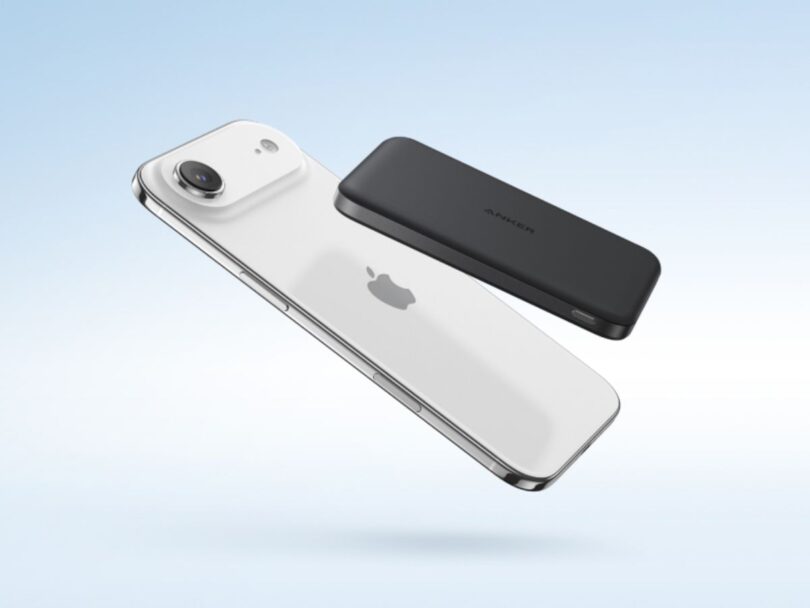 Batterie externe Anker Nano Power Bank MagGo Slim noire fixée magnétiquement au dos d'un iPhone blanc.