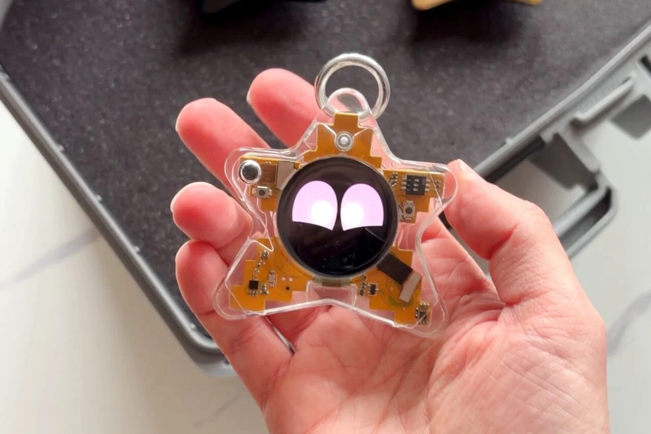 Vue détaillée de la version transparente du Starboy montrant les circuits imprimés, les capteurs et l'écran OLED central affichant des yeux violets.