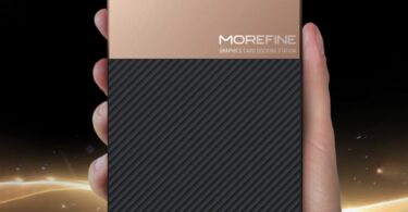 Vue de dessus du boîtier eGPU Morefine G2 tenu dans une main, illustrant sa taille ultra-compacte. Le châssis présente une finition bicolore or brossé et noir strié avec le logo Morefine Graphics Card Docking Station.