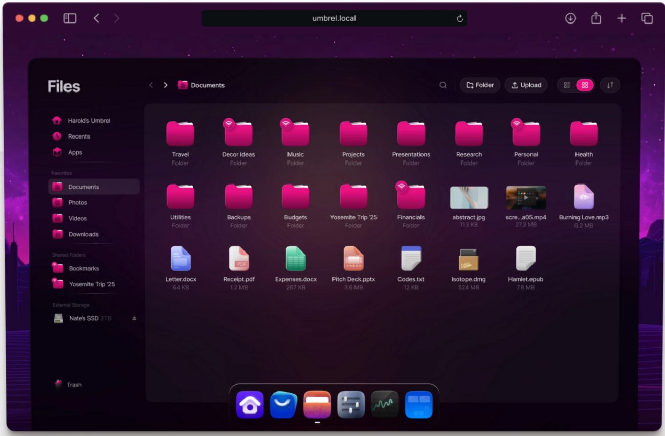 Interface de l'application Files d'UmbrelOS montrant un explorateur de fichiers moderne. On aperçoit des dossiers roses (Documents, Photos, Vidéos), divers types de fichiers (PDF, DOCX, MP3) et une barre latérale affichant un stockage externe connecté nommé "Nate's SSD 2TB".