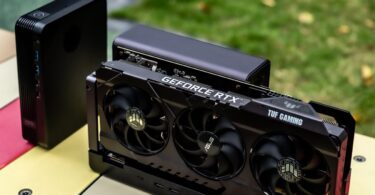 Dock eGPU GPD G2 avec une carte graphique ASUS TUF Gaming GeForce RTX installée, montrant le connecteur MCIO et les ports de connectivité sur une table colorée.