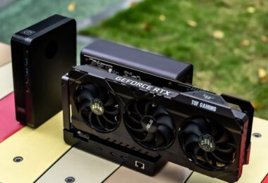 Dock eGPU GPD G2 avec une carte graphique ASUS TUF Gaming GeForce RTX installée, montrant le connecteur MCIO et les ports de connectivité sur une table colorée.
