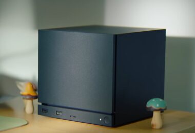 Image conceptuelle générée par IA d'un mini-PC Valve compact et élégant, positionné sur un bureau en bois. L'appareil est un cube noir mat aux lignes épurées, illustrant l'esthétique possible de la nouvelle console de salon de l'entreprise.