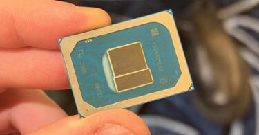 Gros plan sur un processeur Intel Core 3 304 de l'architecture Wildcat Lake tenu entre deux doigts, montrant le die (puce) et le package avec les marquages de série "Q9D6" et "00221".