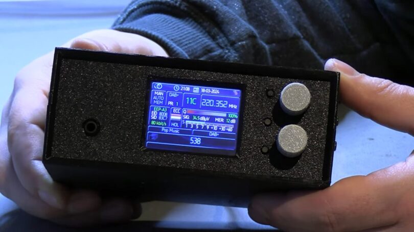 Récepteur radio numérique DAB+ DIY basé sur un ESP32 et une puce Skyworks SI4684, affichant les données techniques (fréquence 220.352 MHz, signal 34.5 dBuV) sur un écran LCD couleur avec deux encodeurs rotatifs.