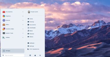 Capture d'écran du bureau Zorin OS 18.1 montrant le menu "Zorin" ouvert avec les catégories d'applications, le dossier utilisateur et un fond d'écran de montagnes enneigées au coucher du soleil.