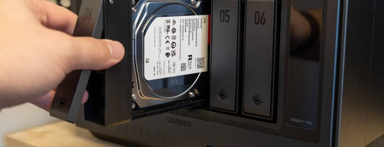 Main d'un utilisateur insérant un tiroir de disque dur Seagate IronWolf 4 To dans la baie d'un NAS multi-baies Ugreen, opération d'extension de stockage NAS en cours.