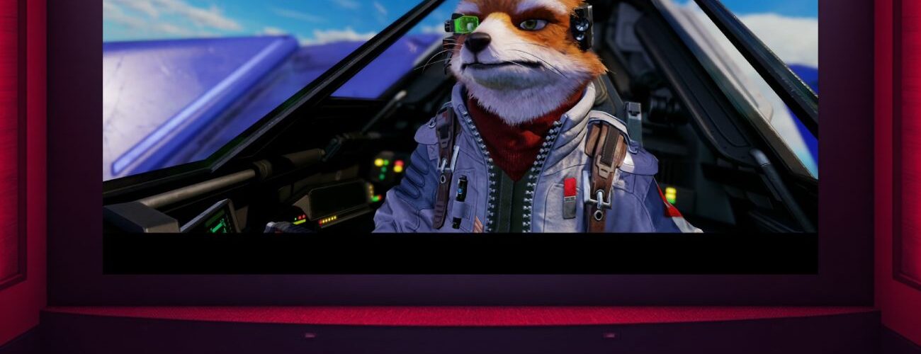 Vue d'une salle de cinéma vide, tous les sièges rouges sont inoccupés, faisant face à un grand écran lumineux projetant une scène du film Star Fox avec le personnage Fox McCloud dans son cockpit Arwing.