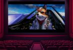 Vue d'une salle de cinéma vide, tous les sièges rouges sont inoccupés, faisant face à un grand écran lumineux projetant une scène du film Star Fox avec le personnage Fox McCloud dans son cockpit Arwing.