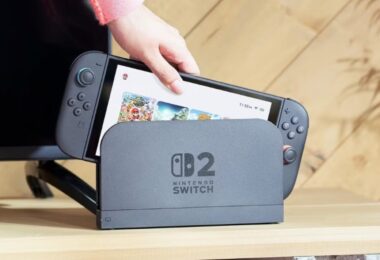 Visuel conceptuel d'une Nintendo Switch 2 insérée dans sa station d'accueil grise affichant le logo "Switch 2", illustrant l'annonce de la hausse de prix de 10 000 yens au Japon.