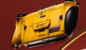 Vue arrière de la console Asus ROG Xbox Ally X moddée aux couleurs de Cyberpunk 2077. On y voit la finition jaune néon avec des effets de vieillissement marqués, le logo Republic of Gamers, et des décalcomanies "Warning" et "No Future".
