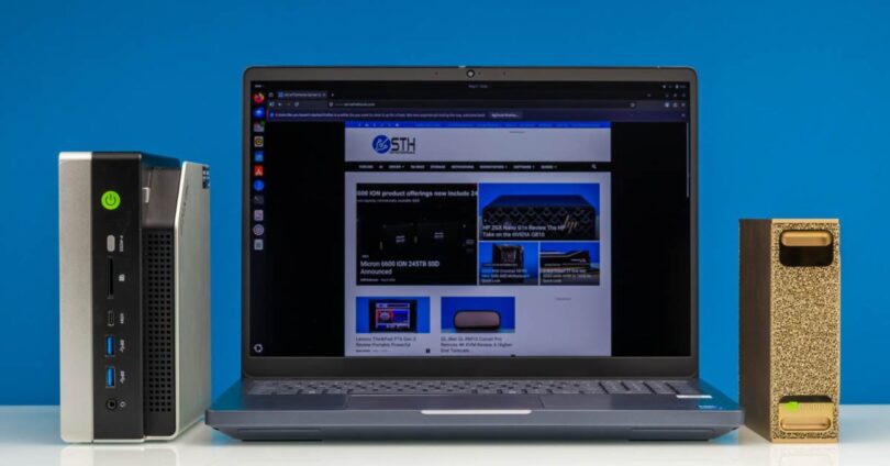 Banc de test SPEC CPU 2026 avec ordinateur portable Lenovo ThinkPad P16 Gen 3 affichant les résultats de benchmark, mini-PC Ryzen AI Max+ 395 à gauche et NVIDIA DGX Spark à droite sur fond bleu.