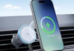 Chargeur de voiture sans fil Ugreen Qi2 fixé sur une grille d'aération, rechargeant un iPhone par induction avec un indicateur de charge circulaire lumineux.