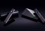 Nvidia Shield TV Pro et Shield TV posées sur fond noir avec leurs télécommandes, la Pro et son liseré vert à droite, le modèle cylindrique à gauche, illustrant la hausse de prix de 2026.